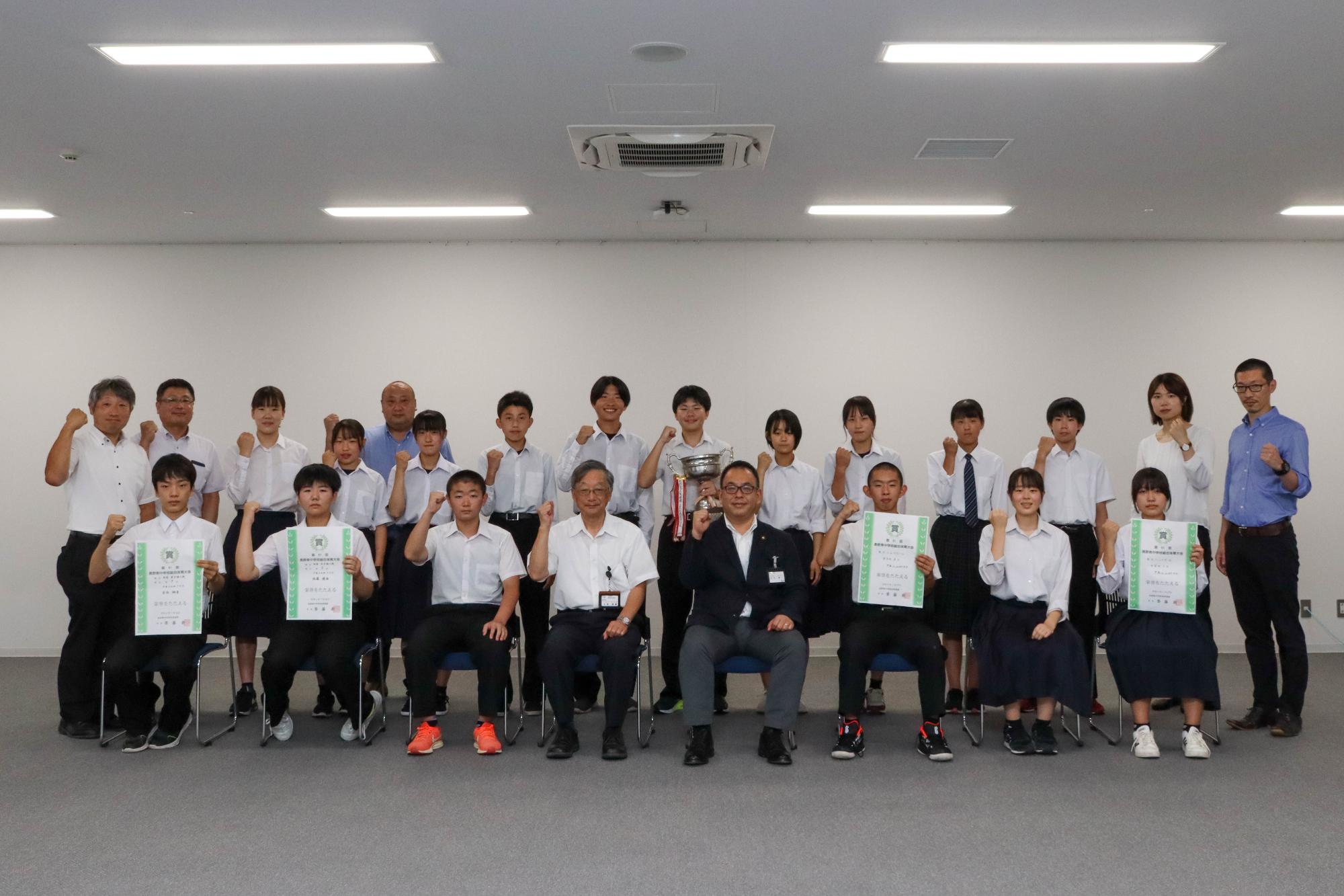 表敬訪問に訪れた生徒、教諭、小川市長、小松教育長がガッツポーズで記念撮影