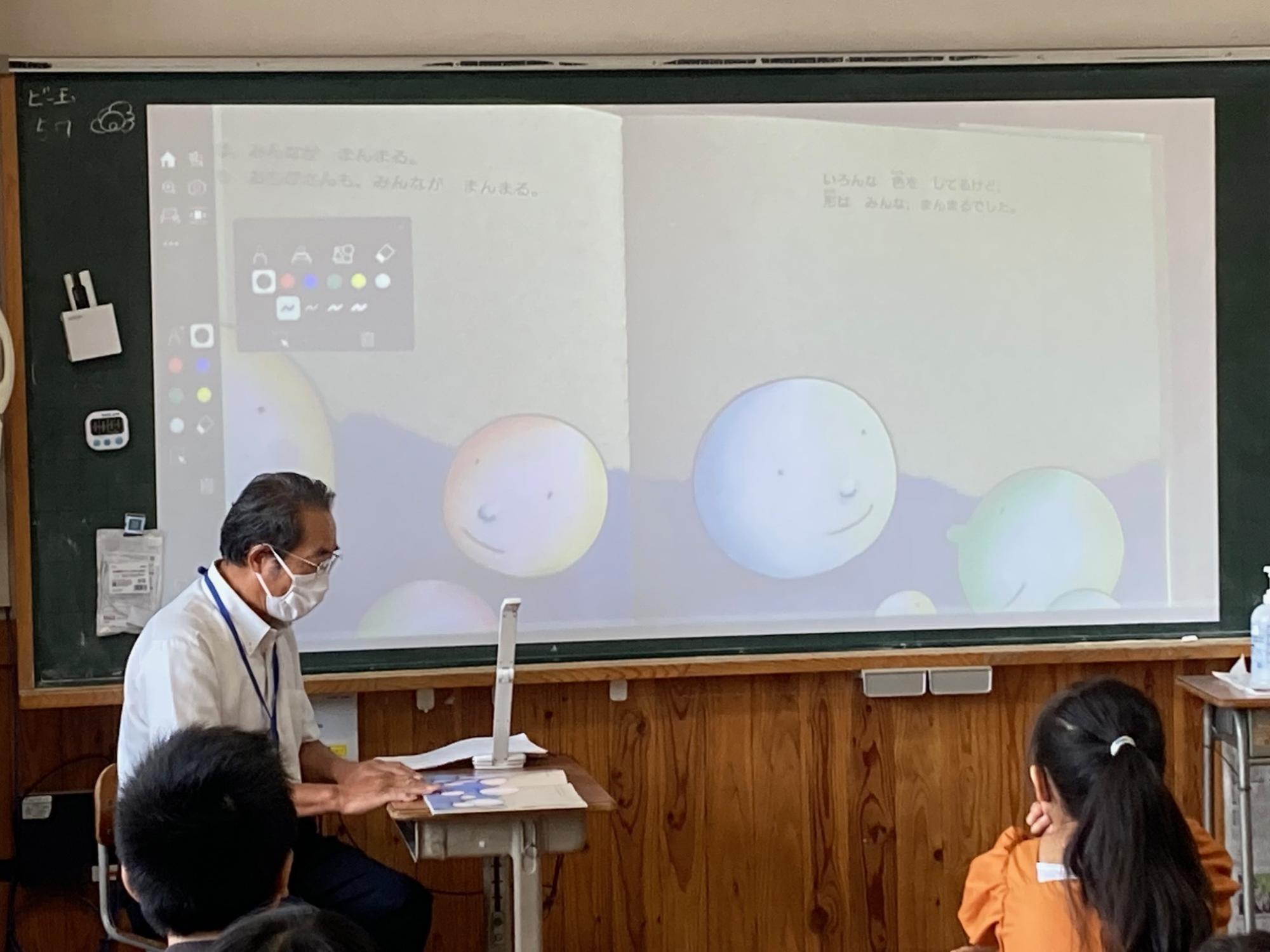 実物投影機を使って読み聞かせをしている様子