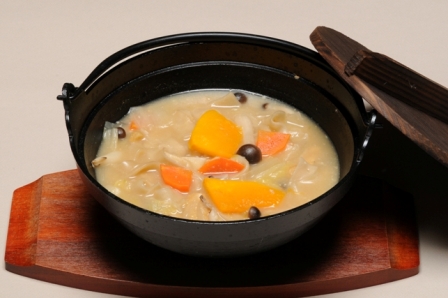 黒い鍋に入った野菜たっぷりの家庭料理「おぶっこ」の写真