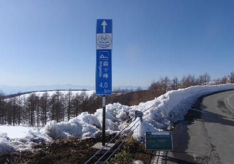霧ヶ峰まであと4.0kmの案内板が設置された道路の写真