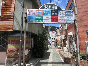 ほろよい銀座という文字の下に様々なお店のロゴが並んでいる看板が、道の入り口に立っている写真