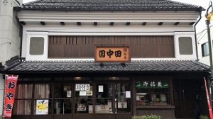 「田中園」と書かれた看板が掲げられている、2階建ての瓦屋根の建物の外観の写真