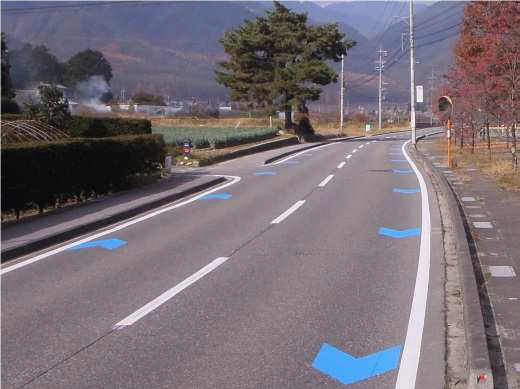 矢羽根型路面標示が塗装された道路の写真