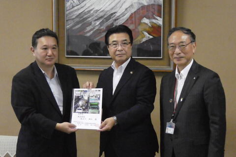 市長と建設部長が冊子を手に持ち、カメラのほうを向いている写真