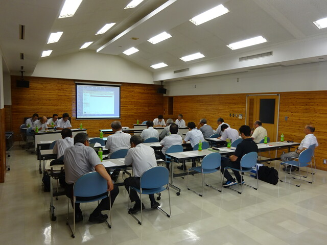スクリーンのある教室内で勉強会が行われている様子の写真