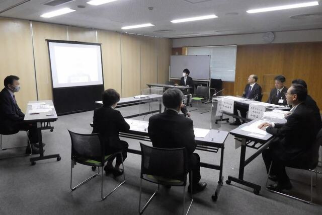 スクリーンに資料を映しながら議論を行う役員らの写真