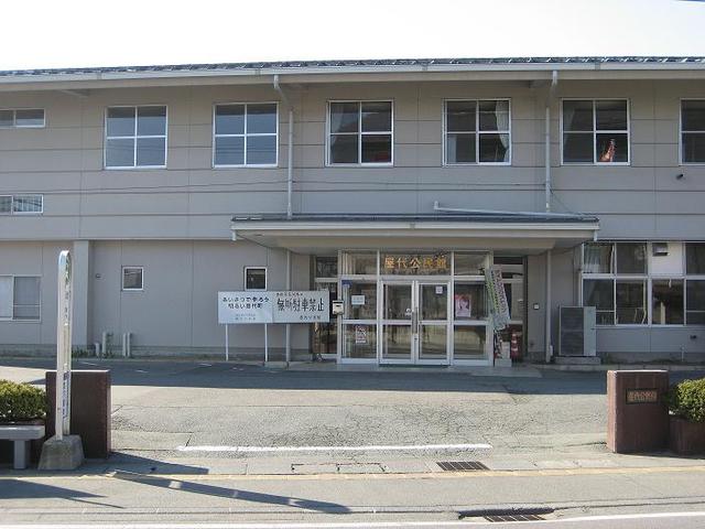 広いコンクリートの場所に立つ白い屋代公民館