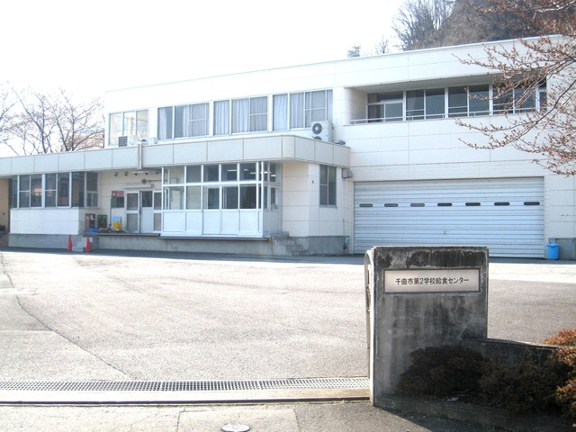 千曲市第2学校給食センターと銘板がかけられた入口から撮影された施設外観の写真