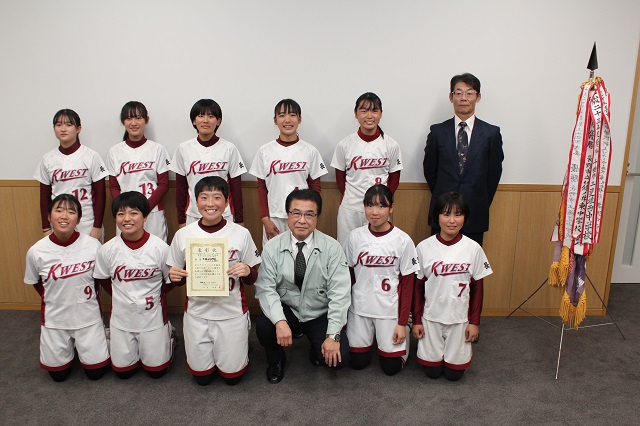 市長とユニフォームを着た選手たちが笑顔で記念撮影をしている写真