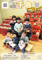 たくさんの人形が並んだ二つのひな壇を背に、子どもたちが集まって立っている、2017年4月号の市報表紙