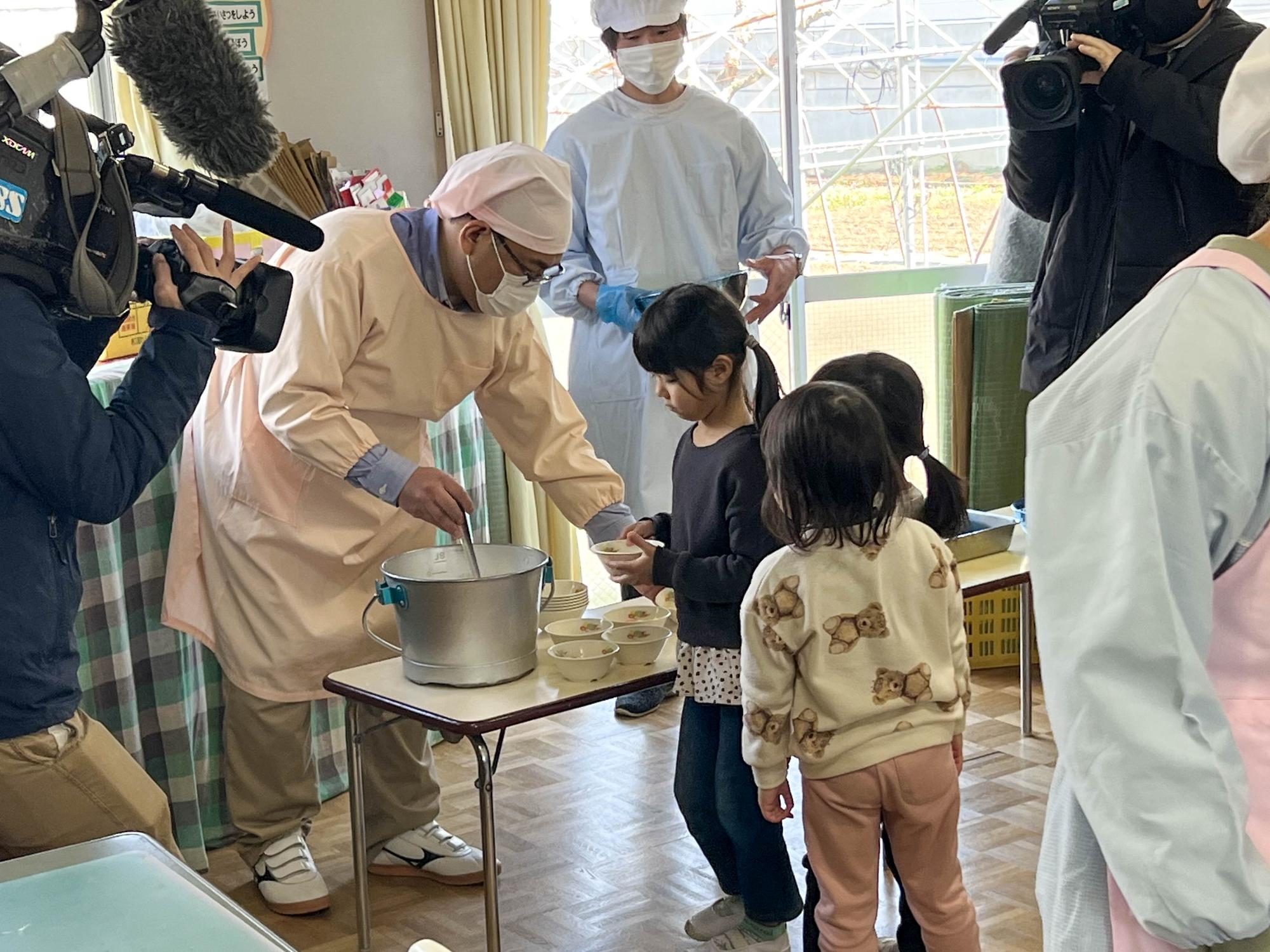 小川修一市長が配膳を体験する様子