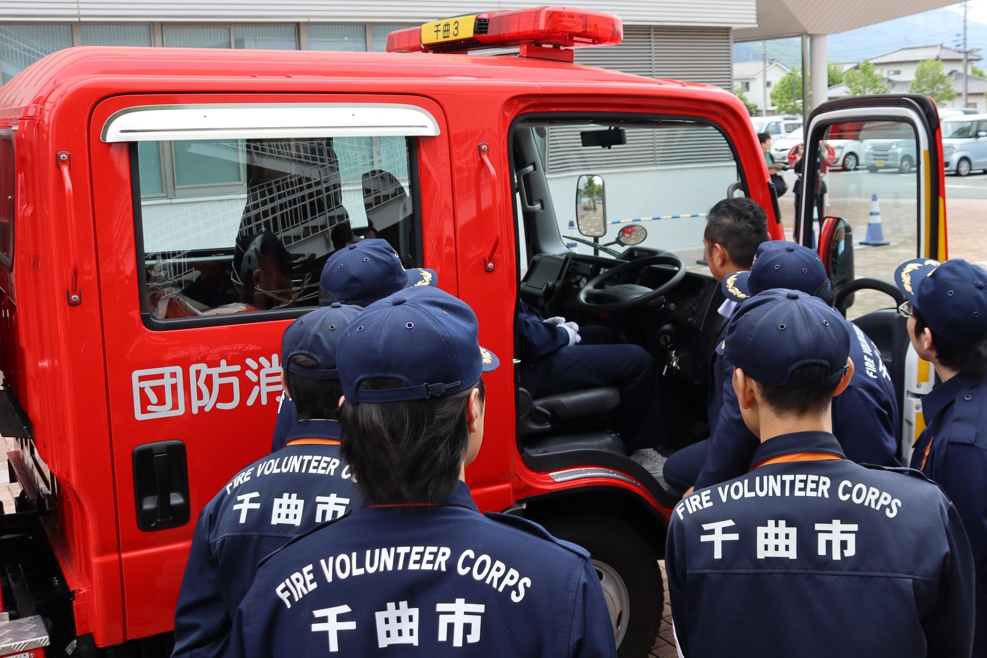 ポンプ車の説明を受ける消防団員