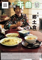 和風の衣服を着た女性の前に、郷土食が盛られた小皿などが並んでいる、2017年5月号の市報表紙