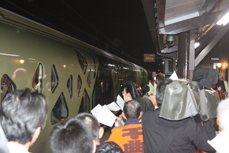 電車をホームで見送る大勢の地元住民の写真