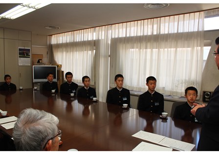 椅子に座り、岡田市長の言葉を聞いている制服姿の男子生徒達の写真