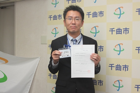 地域おこし協力隊の委嘱状と名札を持った地域おこし協力隊員の男性の写真