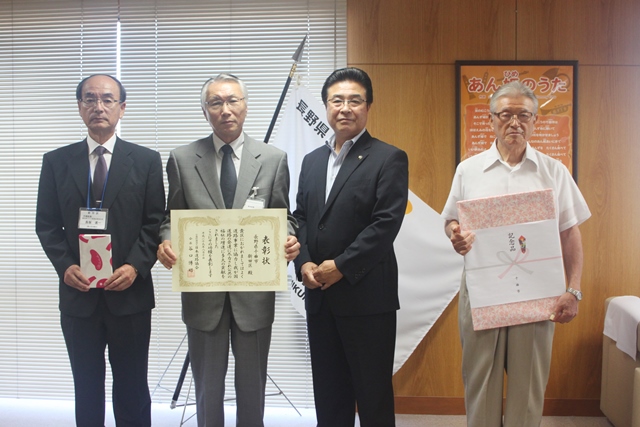 表彰状や記念品などを持った功労者3名と市長が並んで記念撮影をしている写真