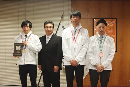 首からそれぞれ金銀銅のメダルを下げ、岡田市長と並んで立つ入賞者の男性3人の写真