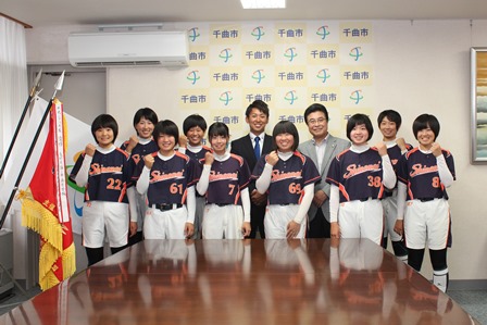 ガッツポーズで笑顔を見せるユニフォーム姿の女子生徒達の集合写真