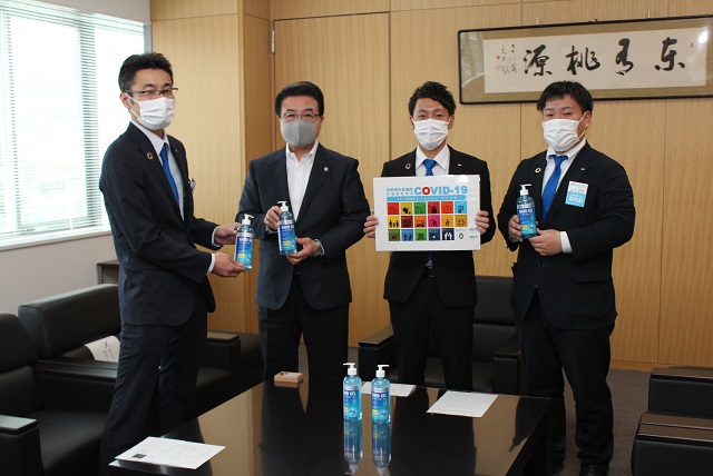 市長と関係者のみなさんが商品のサンプルをカメラのほうに見せながら立っている写真