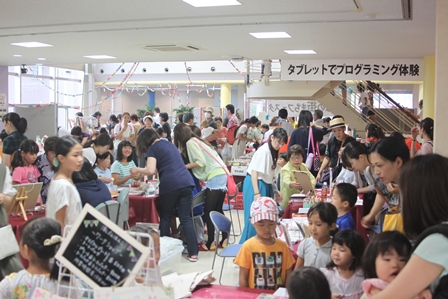 大勢の子供と大人で賑わうフェスタの会場の写真