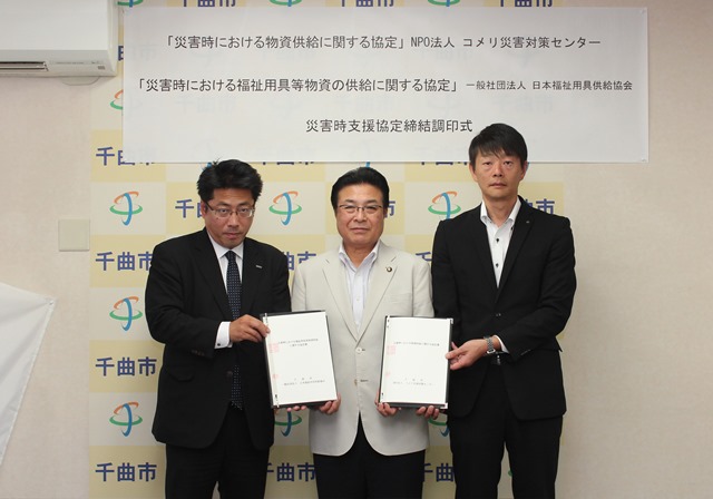 市長が協定書を手にマネージャーらと記念撮影をしている写真
