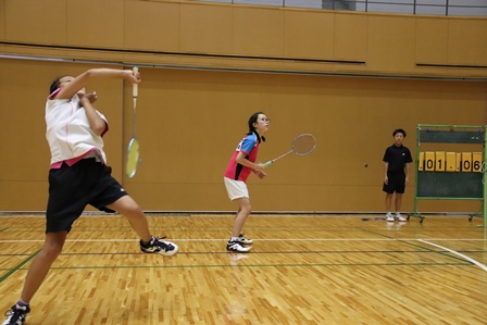 バドミントンのダブルで選手二人が同じチームで試合中の写真