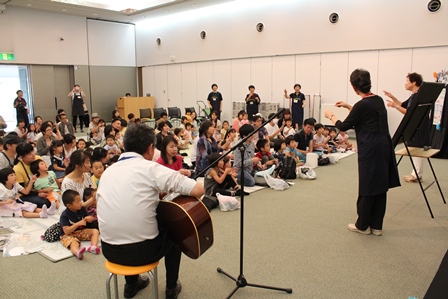 文化会館内で子どもたちに演奏と読み聞かせをしている団体の写真