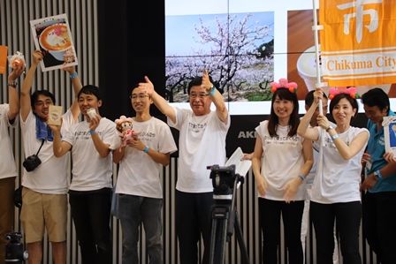 イベントステージの前で千曲市の魅力をPRしている地元住民たちの写真