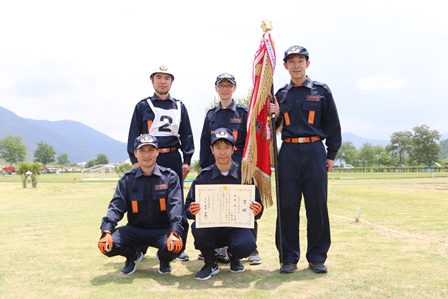 小型ポンプ操法の部で優勝した第12分団三本木班のみなさんが表彰状などを手にして記念撮影をしている写真