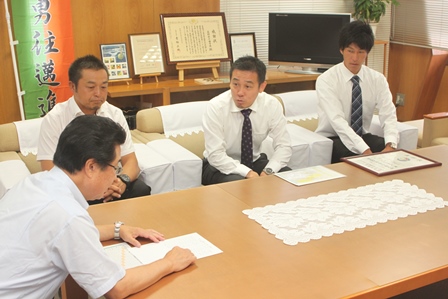 社会人サッカークラブの2名の選手と監督と市長がソファーに座り懇談する写真