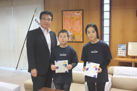 市長と一緒に並んでプレゼントを持っている男の子と女の子の写真