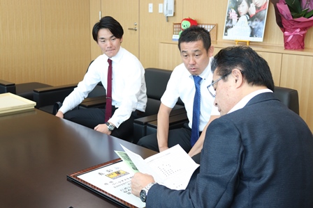 市長と監督、キャプテンが椅子に座ってお話している写真