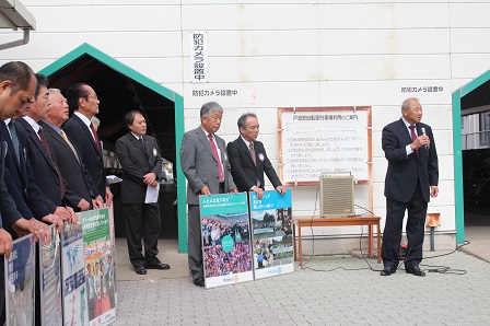 駅前広場で市長と役員の皆さんが集まった人に向けて挨拶を述べている写真