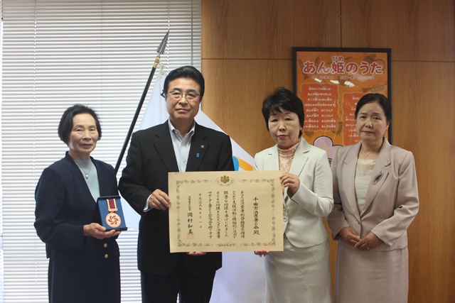 表彰をうけた年配の女性3名と表彰をもって記念写真を撮る市長の写真
