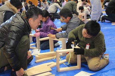 児童が小さな木材にトンカチで釘を打ち込んでいる写真