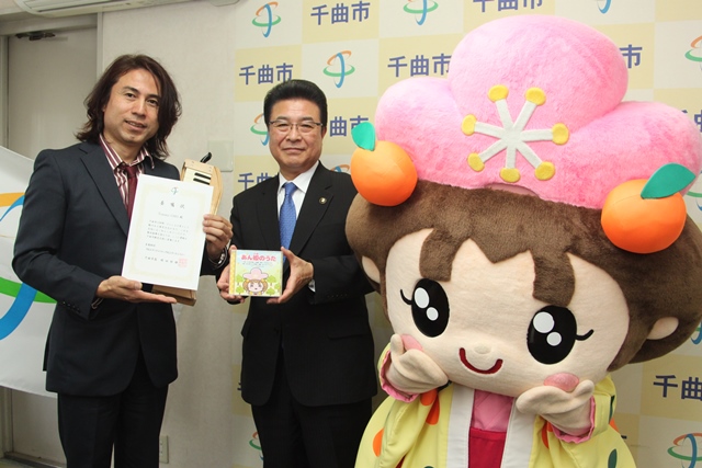 きぐるみマスコット並んでいる市長と委嘱状をもった男性の写真