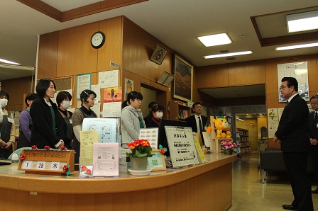 図書館受付に集まった人たちに向けて市長が挨拶をしている写真