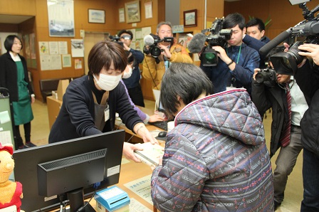 図書館受付で本の貸し出しが行われている写真