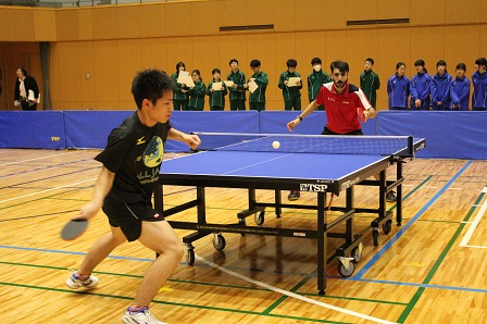 ラケットを手に持ち卓球をしているチーム選手の写真