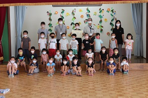 所長と園児たちが一緒に並んで記念撮影をしている写真