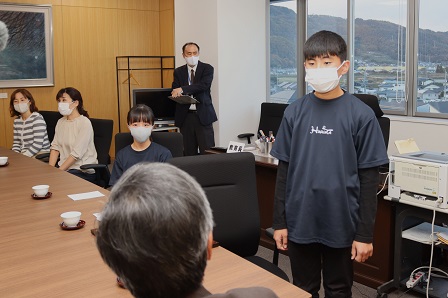 金管バンド部の部長が起立して教育長のほうを向いて挨拶をしている写真