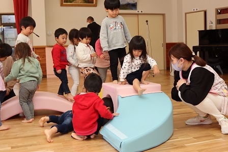 遊具のそばに集まってきた園児たちの写真