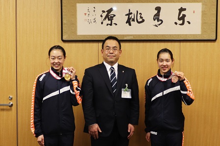 メダルを首から下げて、市長と記念撮影をする和田姉妹の写真