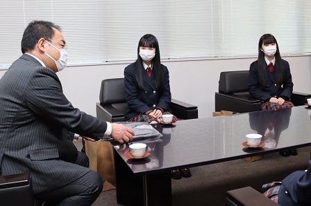 楽らくねまきを手にしながら女子生徒たちとお話している市長の写真