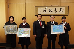 額に入れた絵画を手に持った女子生徒と市長が並んで立ち記念撮影をしている写真