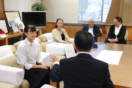 机に座り市長の前で笑顔で話を聞いている女性3人と男性の写真