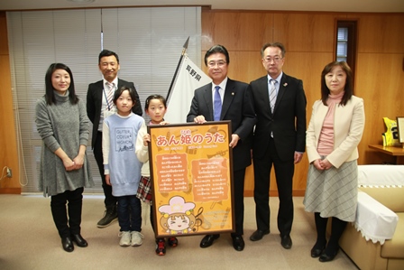 市長と大久保さん、保護者の皆さんが並んで記念撮影をしている写真