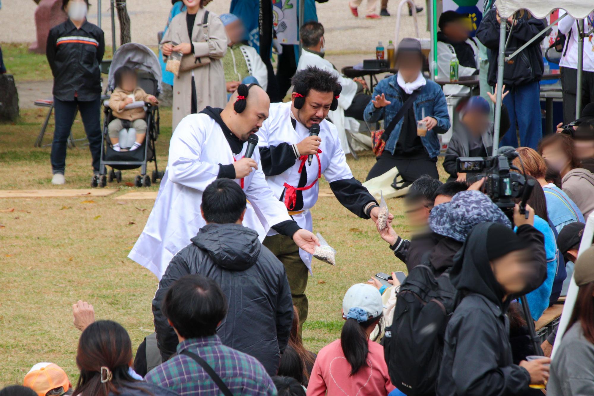 芝生ステージで古墳のPRをしながら観客の皆さんと交流する鬼越トマホーク