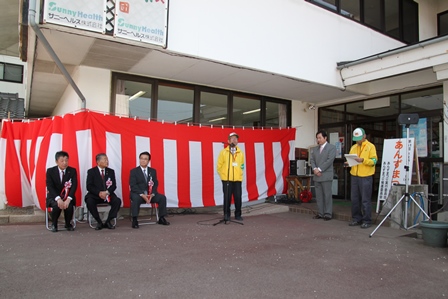 黄色のパーカーを着たあんずまつりの実行委員会会長さんが挨拶をしている様子の写真
